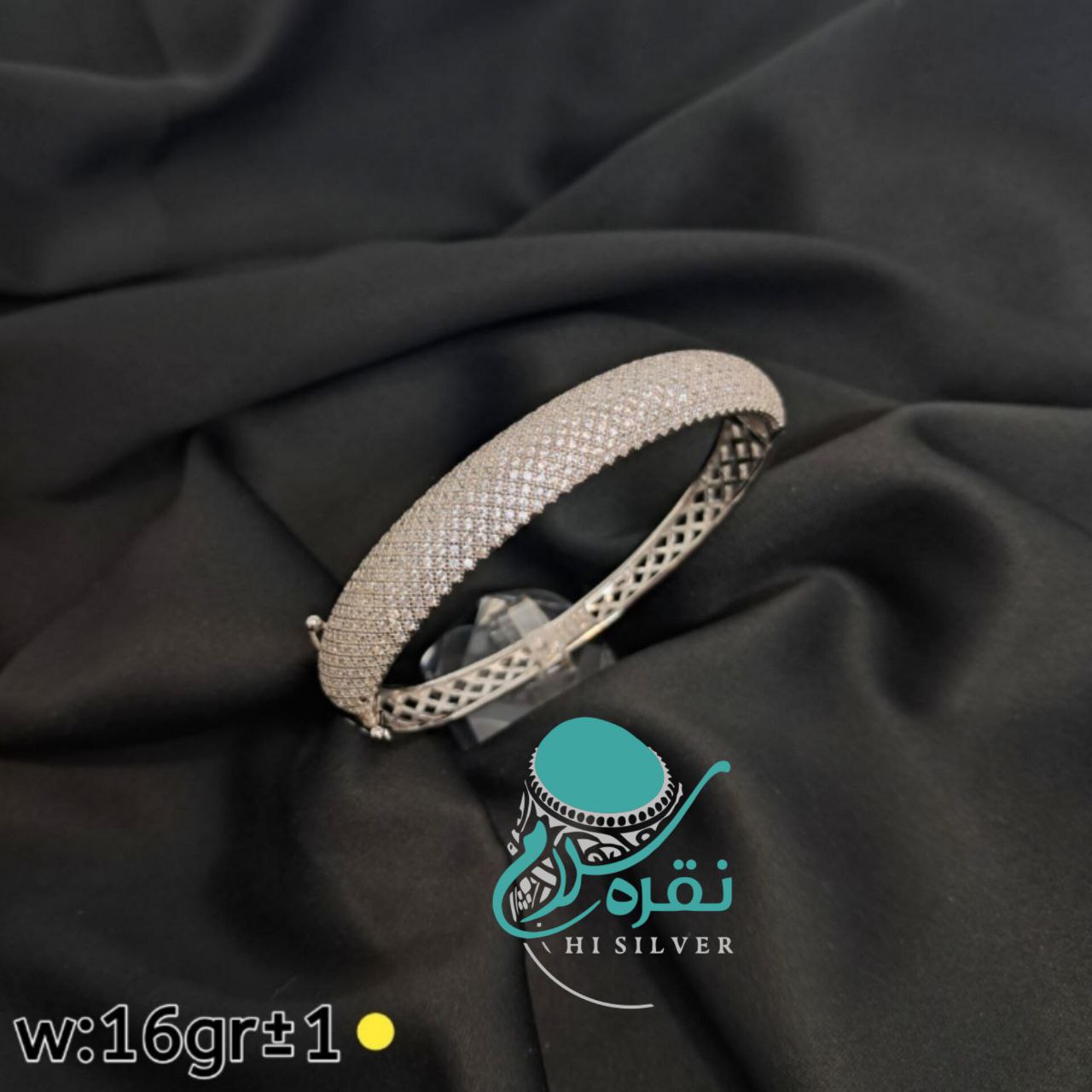 دستبند نقره‌ای با طراحی مشبک و سنگ‌های ریز و درخشان